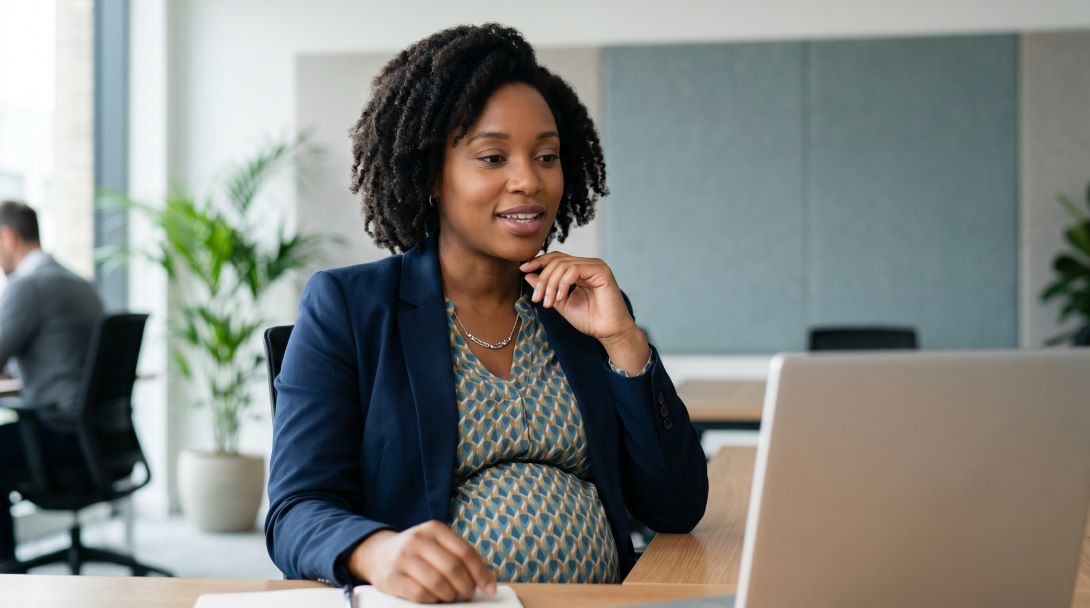 pregnant employee working at desk